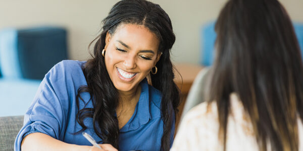Female business owner smiles while conducting interview The mid adult female business owner smiles as she conducts an interview with the unrecognizable woman.