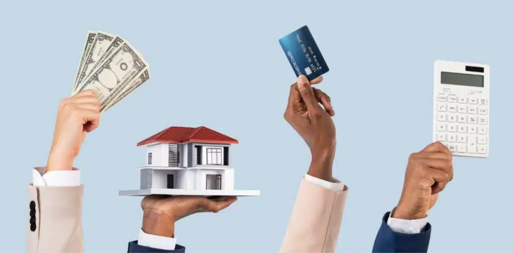 A person with French-manicured nails counts multiple US $100 bills next to a black calculator on a white desk